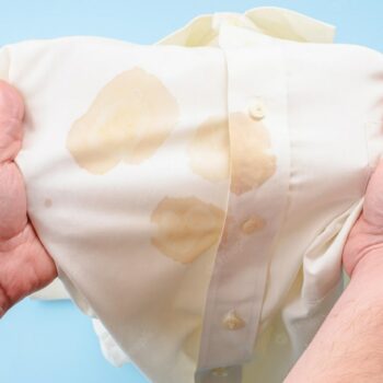 mans-hands-holding-shirt-with-dirty-stain-from-food-stain-soy-sauce-shirt-isolated_556462-168