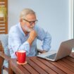 senior-man-executive-with-white-hair-using-computer-laptop-watching-movie-home-with-coffee_554837-205