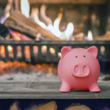 Savings,Concept.,Piggy,Bank,With,Fireplace.,Energy,Saving,Concept.,Pink