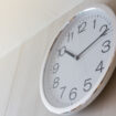 White,Metal,Clock,On,Wooden,Wall,With,Warm,Light,In
